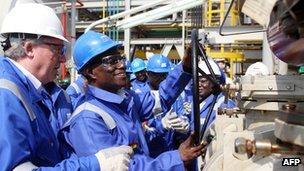 Ghanaian President John Atta Mills (second from right) turns a valve to start Ghana's first oil production at the FPSO Kwame Nkrumah oil rig, at the Jubilee field, on 15 December 2010.