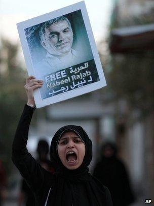 A Bahraini anti-government protester chants slogans as she holds up a pictures of jailed human right activist Nabeel Rajab, 3 December 2012