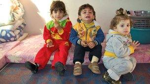Three small children of Maimoun, a Palestinian refugee, seated on a mattress in their room at Cyber City camp