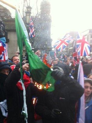 Loyalists set fire to an Irish tricolour outside Belfast City Hall