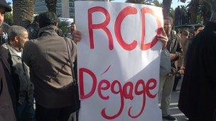 Pro-government protester in Tunis holding up a placard reading "RCD Degage"