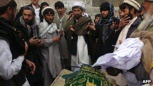Afghan men pray during the funeral of Najia Sidiqi, the acting director of the women"s affairs department in Mihtarlam on December 10, 2012
