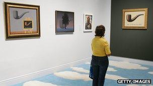 An art lover admires Magritte's 'Ceci n'est pas une pipe' at an exhibition in California