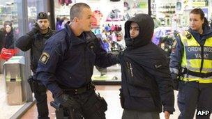 Police restrain a man at a shopping centre in Gothenburg, Sweden (18 Dec 2012)