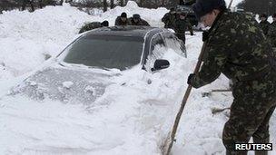 Emergency workers dig out a car trapped in snow in western Ukraine. Photo: December 2012