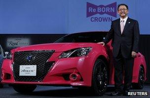 Toyota president Akio Toyoda poses next to the company's remodelled Crown Athlete car