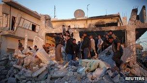 Men search for survivors after an air strike by a fighter jet loyal to Syrian President Bashar el-Assad in Azaz city, North Aleppo, 29 December 2012