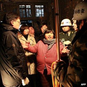 Woman identified as Yuan Lihai talks to officials at scene of fire. 4 Jan 13
