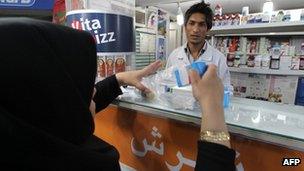 A woman buys medicine in a pharmacy in Tehran