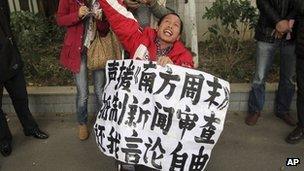 A man holds a banner saying "Support Southern Weekly, boycott news censorship and return my freedom of speech" outside the newspaper"s headquarters in Guangzhou on 8 January 2013