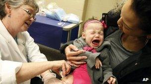 A baby receives a flu vaccine 11 January 2012