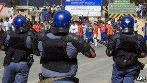 Police observer striking farm workers in South Africa's Western Cape province on 9 January 2013