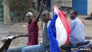 Malian people wave a French national flag
