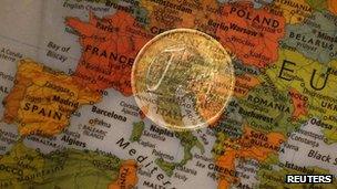 Euro coin superimposed over a map of Europe