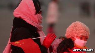 Beijing residents mask their faces against the smog on 30 January 2013