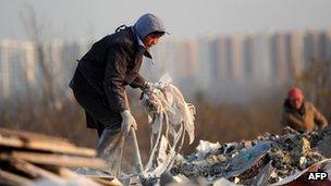 A Chinese resident going through a waste dump