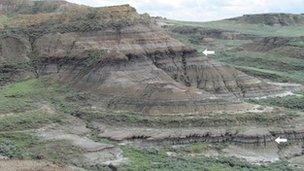 Rock layers near Jordan, Montana exposing the level (lower arrow) where the dinosaurs and many other animals and plants went extinct.