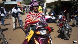 A woman in colourful dress on a motorbike in Gao, Mali - 30 January 2013