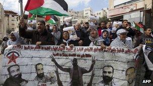 Palestinian protestors wave their national flag and hold portraits of Samer Issawi in East Jerusalem - 15 February
