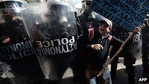 A demonstrator tries to pass a riot police cordon during a strike in Athens (20 Feb 2013)