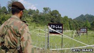 A Pakistani soldier watches Indian soldiers at the Tattapani-Mendher crossing point on the Line of Control, some 35km from Kotli, in Pakistani administered Kashmir, 09 September 2006