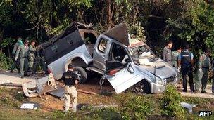 Thai bomb squad members inspect the site of a roadside bomb attack by suspected separatist militants in Thailand's restive southern province of Narathiwat, 30 January 2013