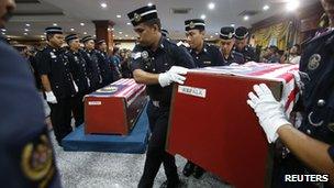 Malaysian police carry a colleague's coffin