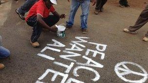 Solomon Muyundo painting "Peace Wanted Alive" all over Kibera