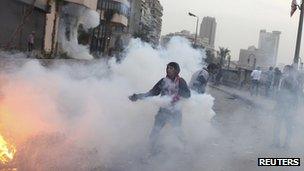 A protester runs with a tear gas canister in Cairo. File photo