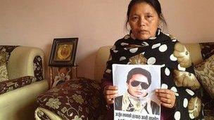 Purnimaya Lama holds up a picture of her dead husband Arjun