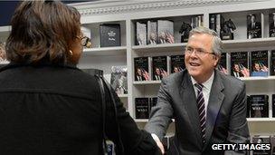 Jeb Bush shakes a woman's hand at a book signing