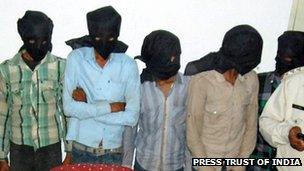 Five hooded suspects during a press meeting in Datia