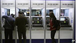 Depositors try to use automated teller machines of Shinhan Bank while the bank's computer networks are paralyzed at a subway station in Seoul, South Korea, Wednesday, March 20, 2013.