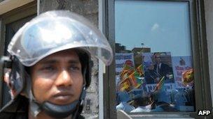 Pro-government activists are reflected in the glass of the US embassy during a protest in Colombo on March 21, 2013,