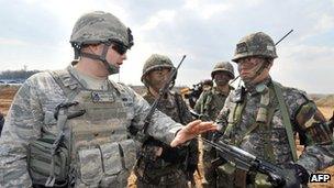 A US air force soldier, left, talks to South Korean army soldiers during an operation to guard a US airbase as part of annual joint exercises outside the airbase in Pyeongtaek, south of Seoul, 14 March 2013