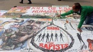 An artists works on a banner calling for the death sentence for rapists in Delhi, 16 January 2012