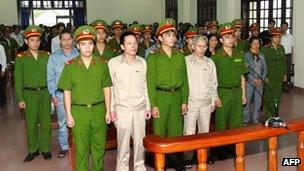 Fisher farmer Doan Van Vuon (second left, front row) and his family members stand trial at a local People's Court House in the northern coastal city of Haiphong, 2 April 2013