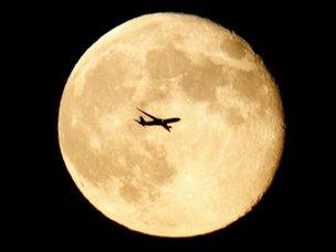 Jet flies in front of moon