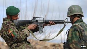 An Afghanistan National Army soldier checks a weapon in Helmand