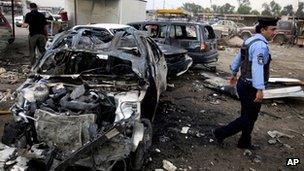 A policeman inspects the aftermath of a car bomb attack at a used cars dealers parking lot in Habibiya neighbourhood of eastern Baghdad, Iraq, Tuesday, April 16, 2013.