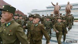 North Korean soldiers visit the bronze statues of North Korea founder Kim Il-sung (L) and late leader Kim Jong-il at Mansudae in Pyongyang, 15 April 2013