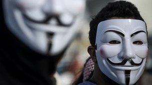 Two men wearing V for Vendetta masks