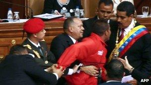 Man is restrained after interrupting Mr Maduro's speech