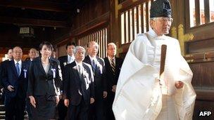 A Shinto priest (R) leads a group of Japanese lawmakers to offer prayers for the country's war dead at the Yasukuni Shrine in Tokyo on the occasion of the shrine's spring festival, 23 April 2013