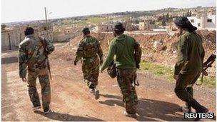 Syrian soldiers walk near scene of alleged chemical weapons attack in Khan al-Assal (23/03/13)