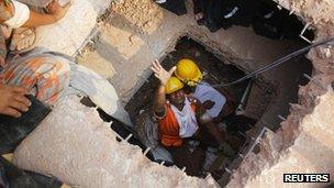 Fire fighters try to rescue garment workers, who are trapped inside the rubble of the collapsed Rana Plaza building