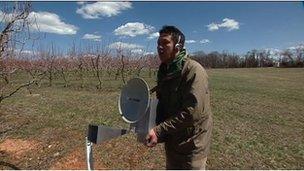 scientist using a radar device in an orchard