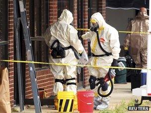 Officials wearing hazmat suits search a martial arts studio previously run by Everett Dutschke in Tupelo (24 April 2013)