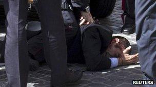 A man believed to be the gunman is detained outside the Chigi palace, Rome, 28 April