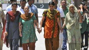 Sarabjit Singh's wife Sukhpreet Kaur, right, sister Dalbir Kaur, second from left, and daughters Poonam, left, and Swapandeep hold hands and walk after entering India at the Pakistan border area of Wagah, India, on Wednesday 1 May 2013